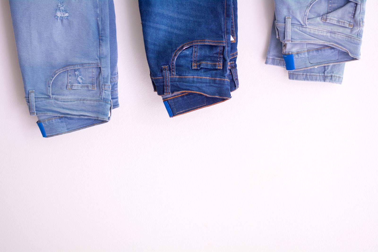Folded jean pairs in several indigo washes illustrating denim end use.